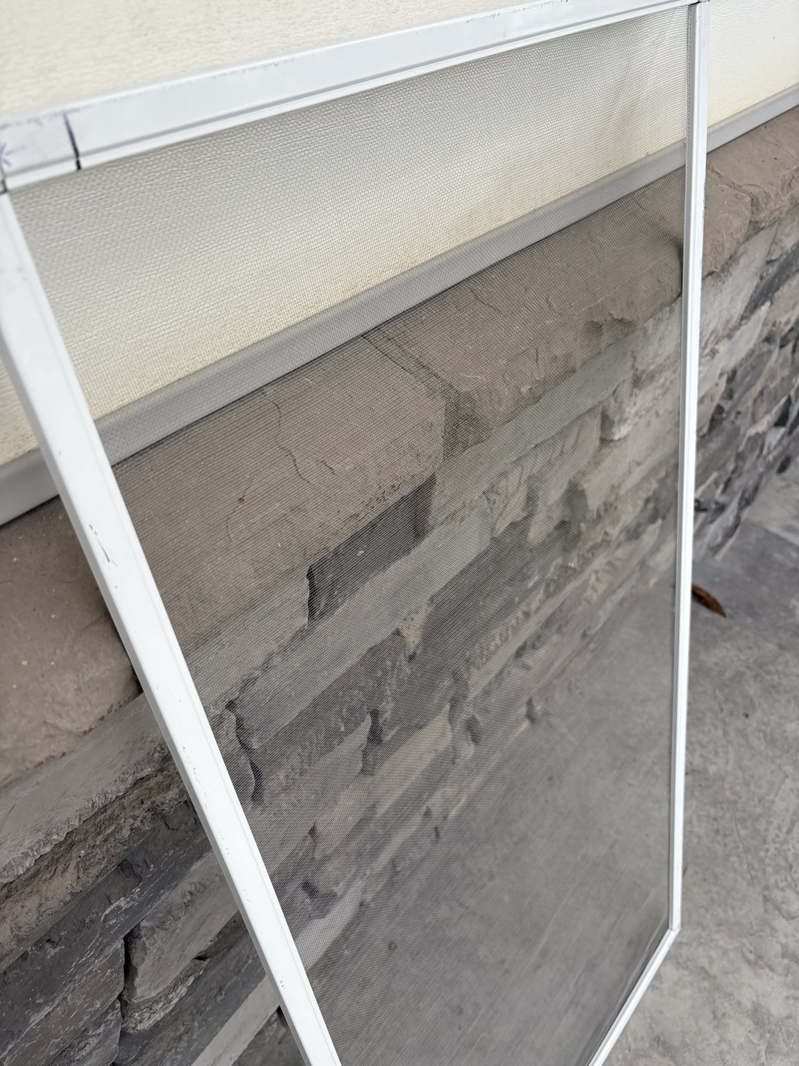 Close-up of a custom-fit screen on a Twin Falls stone wall